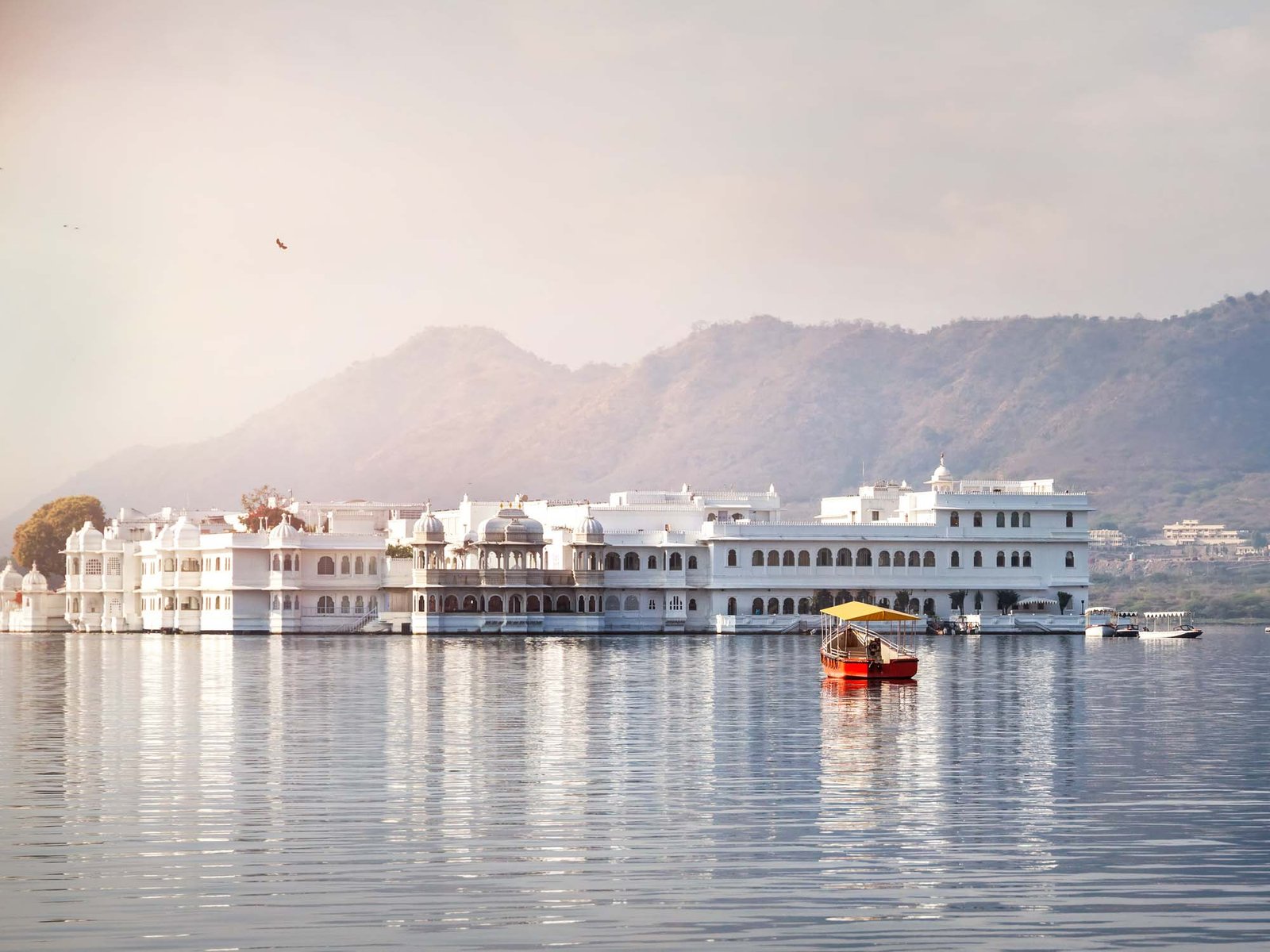 White palace and boat on Lake Pichola in Udaipur, Rajasthan, India